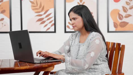 indian mother typing on computer
