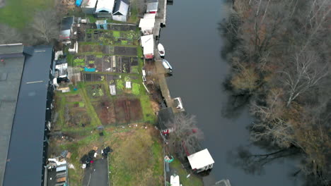 top down shot of shed and small vegetable patches along a calm river