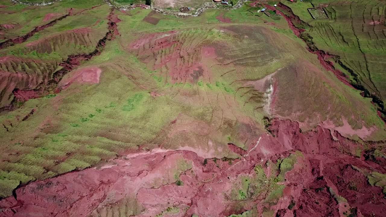 Aerial, tilt up, drone shot over terraces, towards a small town, near Palcoyo, sunny day, in Cusco, Peru, South America