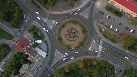 4k aerial view of roundabout road with circular cars in small european city at summer day