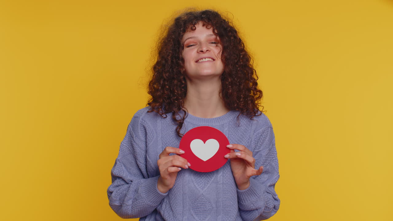 mujer sonriente sosteniendo un icono de corazón