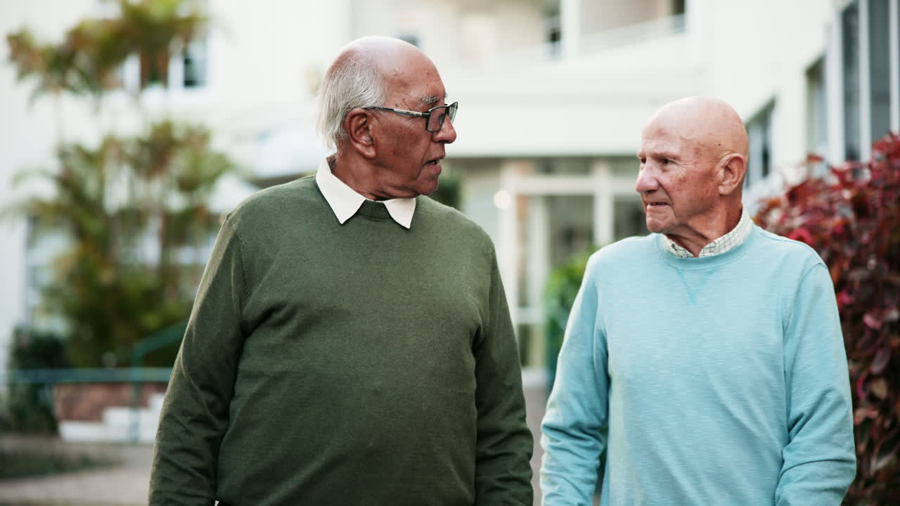 Two elderly men having a conversation outdoors