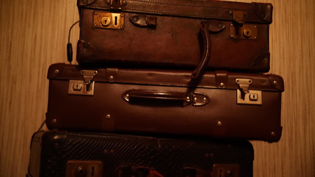 A warm-toned stack of old leather suitcases in a nostalgic interior setting