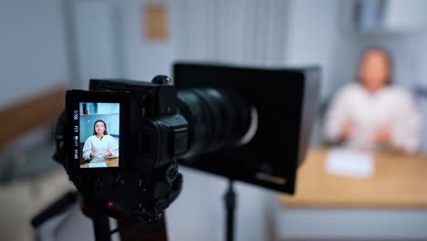 display of camera showing the female presenter speaking. blogging and vlogging concept. close up. blurred backdrop.
