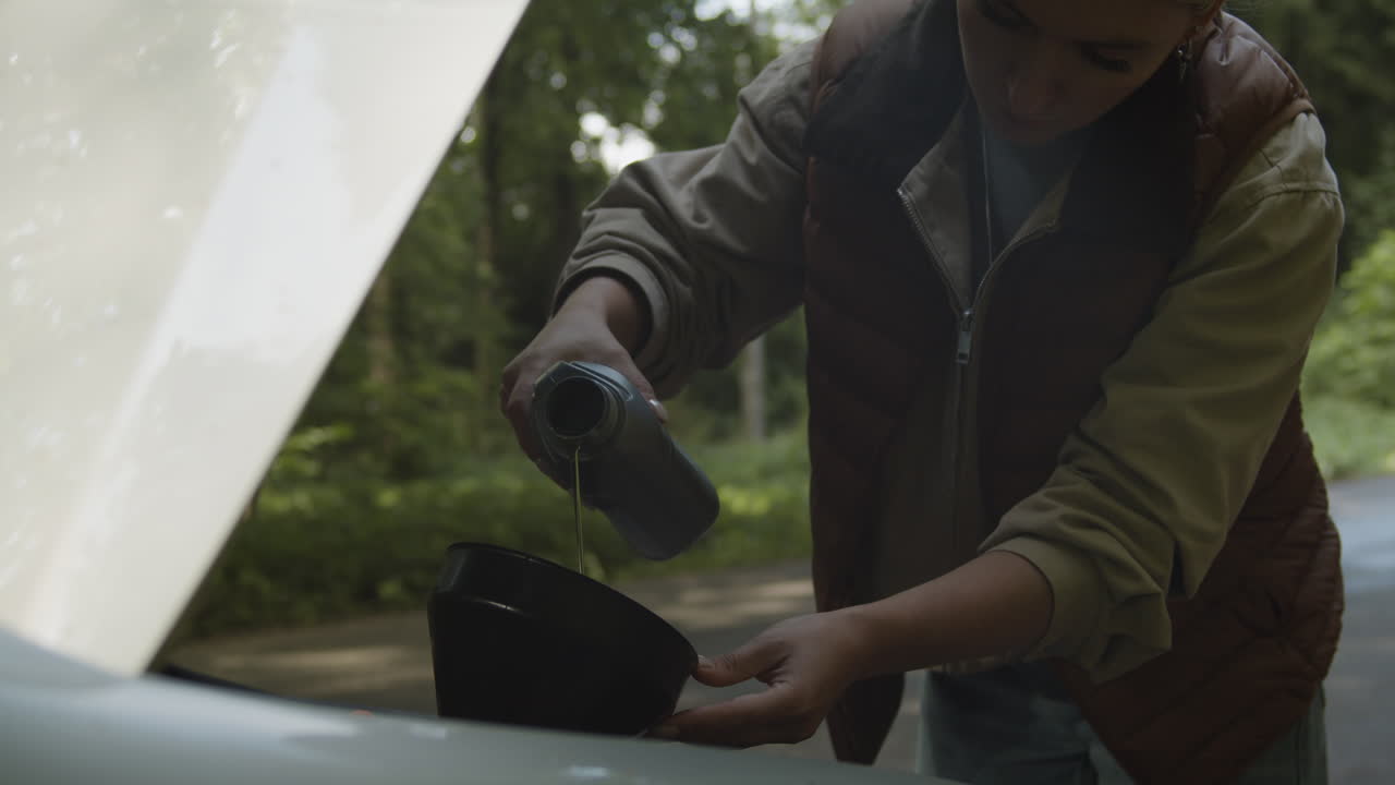 Woman Adding Oil to Car Engine