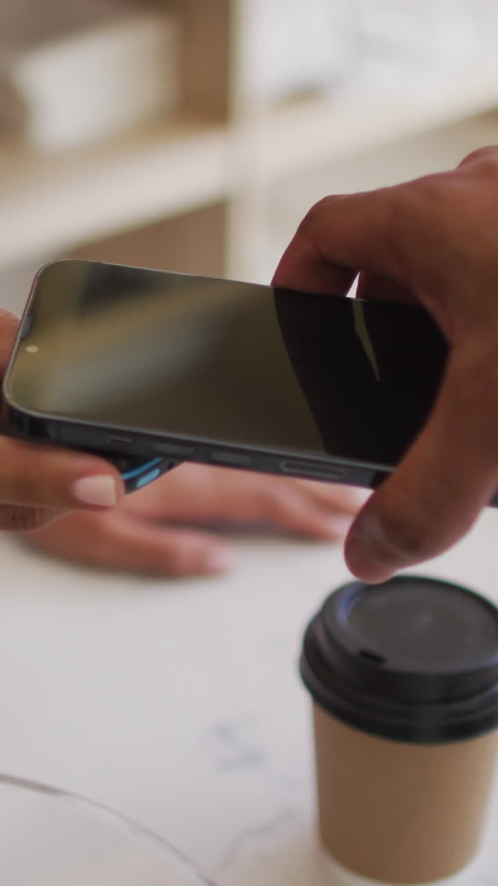 видео рук двухрасового мужчины, оплачивающего кофе с помощью смартфона