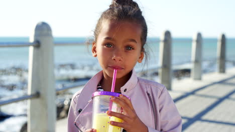 Girl-child,-juice-and-vacation-at-beach-for-smile