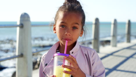 girl child, juice and vacation at beach for smile