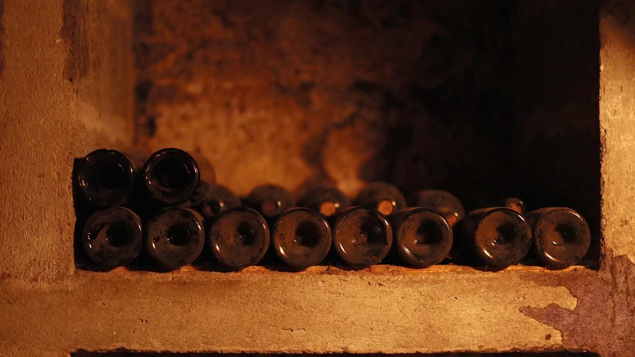 Garrafas de vinho em uma adega com pouca luz