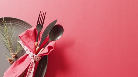 video of christmas place setting with cutlery and copy space on red background