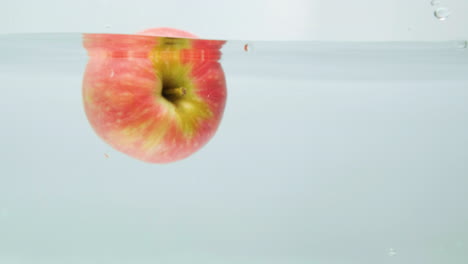 manzana roja cayendo al agua