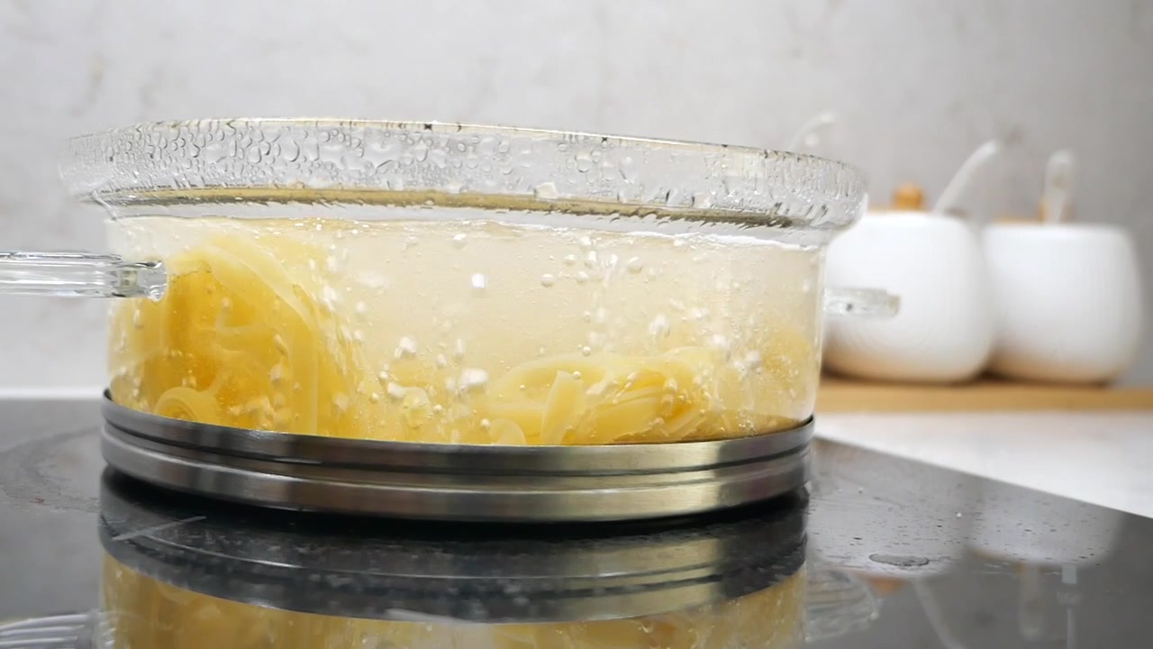 Fettuccine che bollono in una pentola di vetro su un fornello