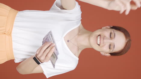 Vertical-video-of-Woman-distributing-banknotes-and-tossing-them-into-the-air.