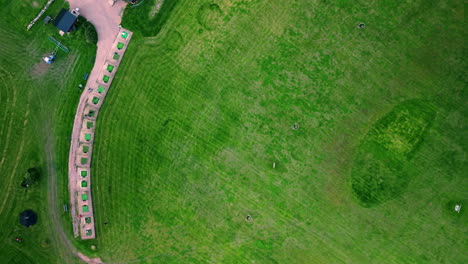 amplio tiro superior de un campo de golf con un par de golfistas practicando