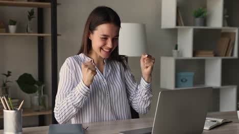 euphoric young female entrepreneur celebrating business achievement.