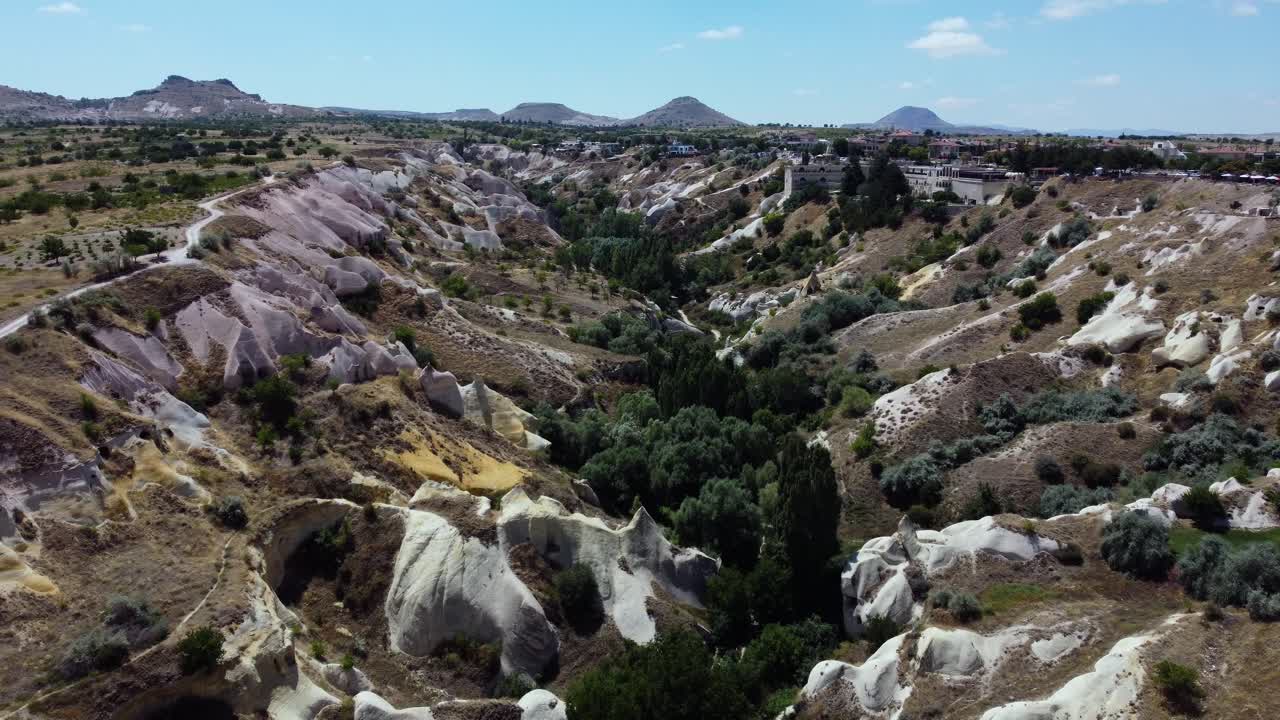Drone dolly across Pigeon Valley rock formations and Uchisar Castle in Cappadocia