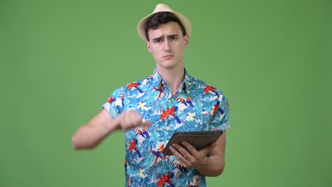 young handsome tourist man using digital tablet and getting bad news