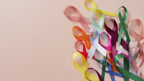 Video-of-colourful-cancer-ribbons-on-pale-pink-background