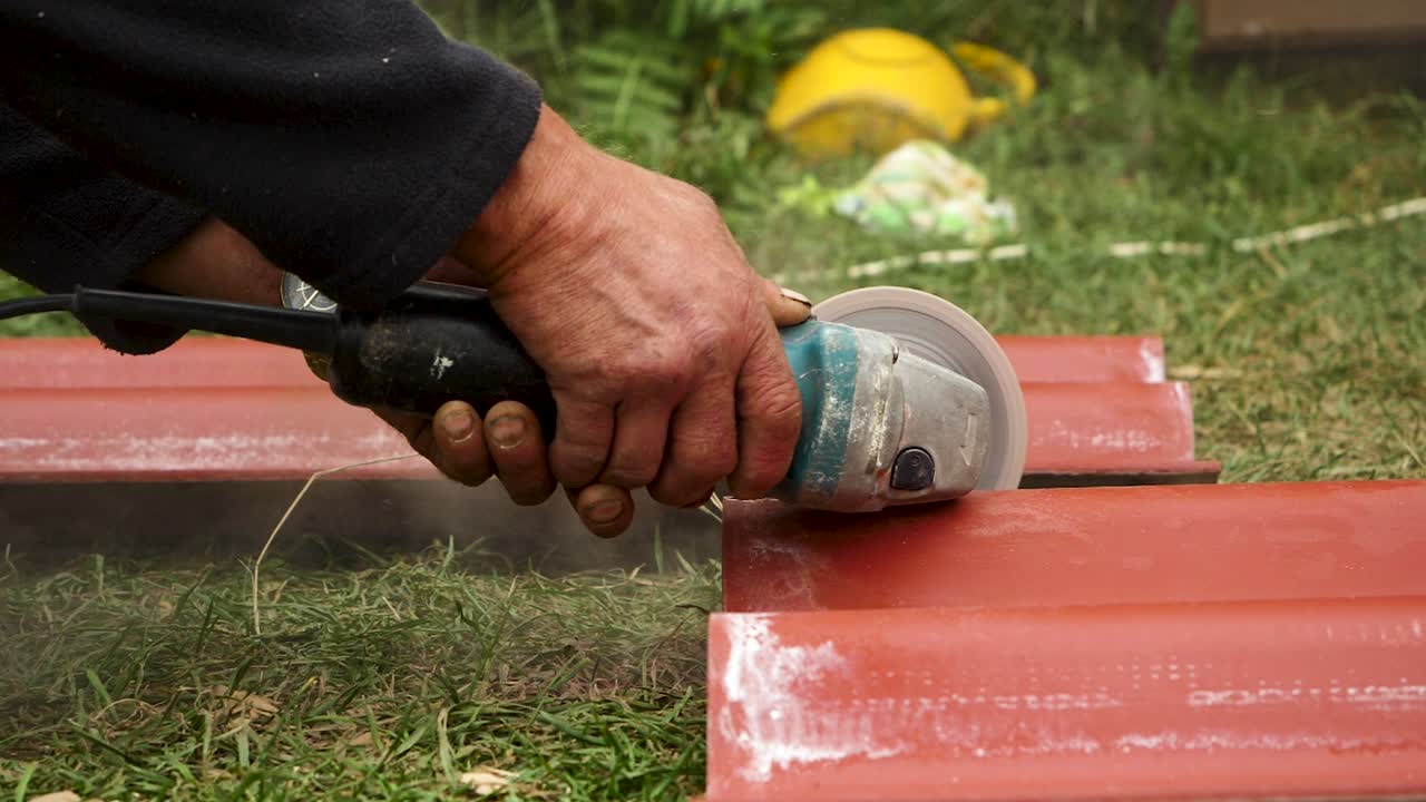 Man Cutting Metal Roofing Tiles with a Grinder