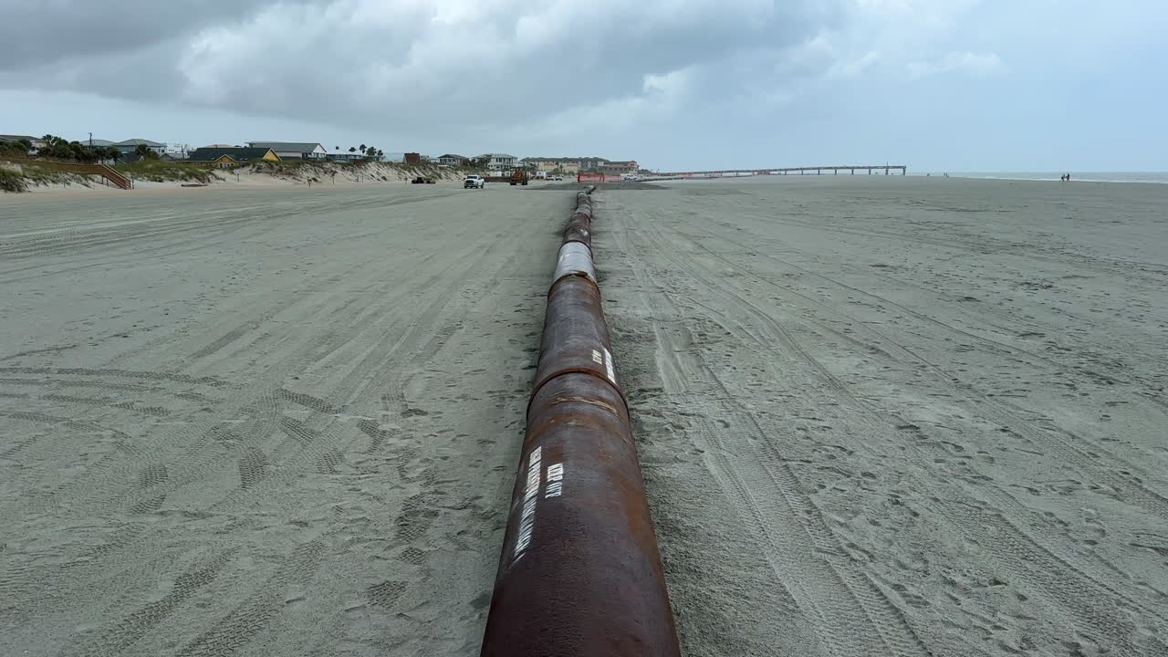 Long pipe pumping sand from ocean for beach replenishment sandscaping