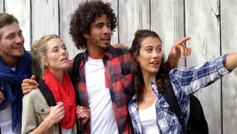 grupo de amigos de pie con la mujer señalando la mano hacia arriba