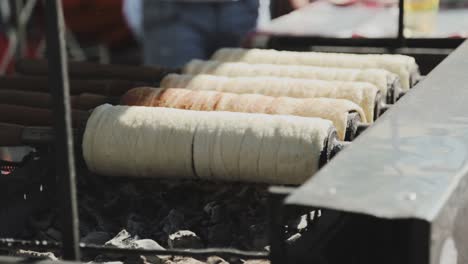 haciendo algunos pasteles de chimenea húngaros sobre la brasa brillante con otra vista pespectiva en el día soleado
