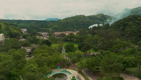 Drone shot of Atenquique, Jalisco, with a factory chimney and a plume of white smoke in distance
