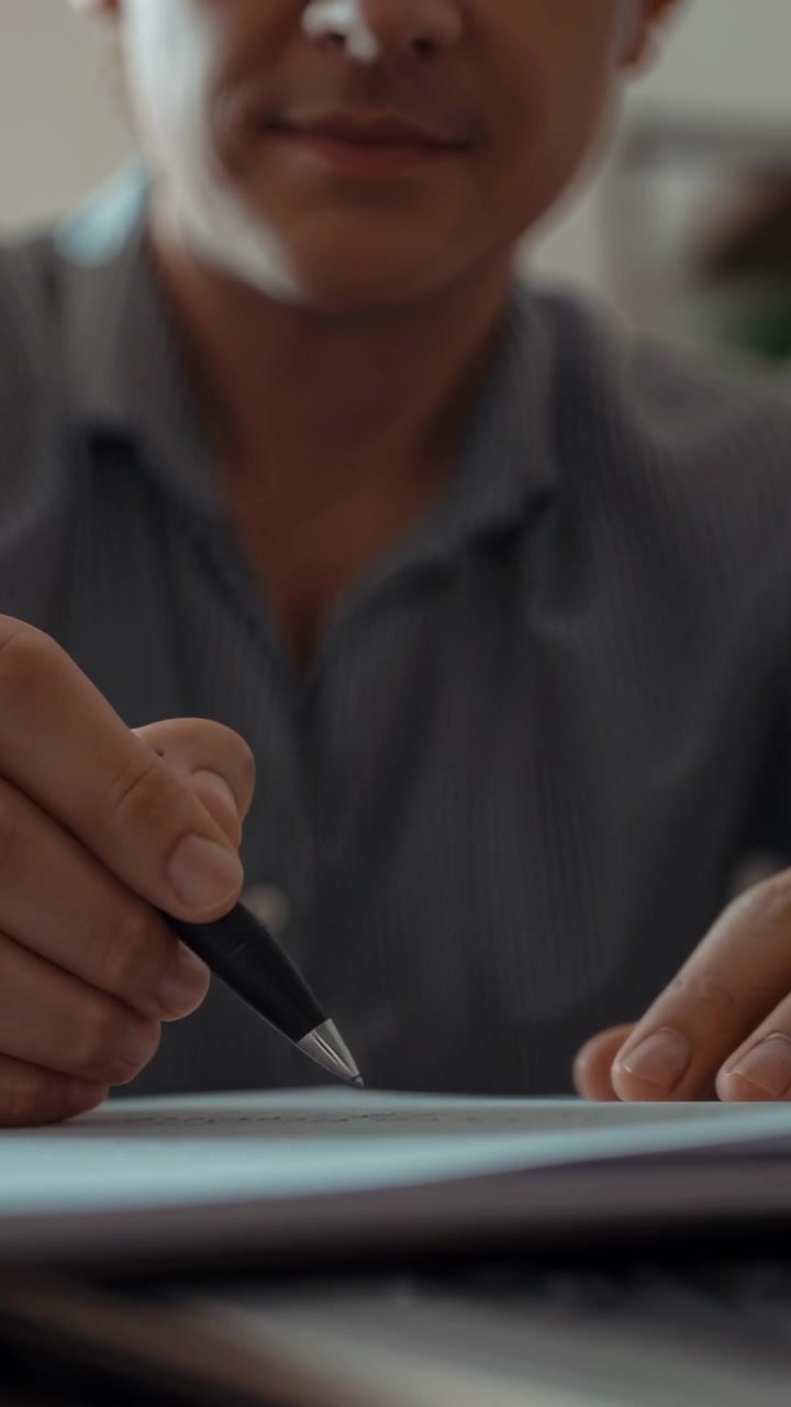 Video verticale: Penna che fluttua, che guida un uomo in camicia con colletto a picchiettare i fogli sulla scrivania, preparandosi a firmare.
