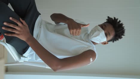 vertical video of african teenager showing covid-19 vaccine bandage merrily