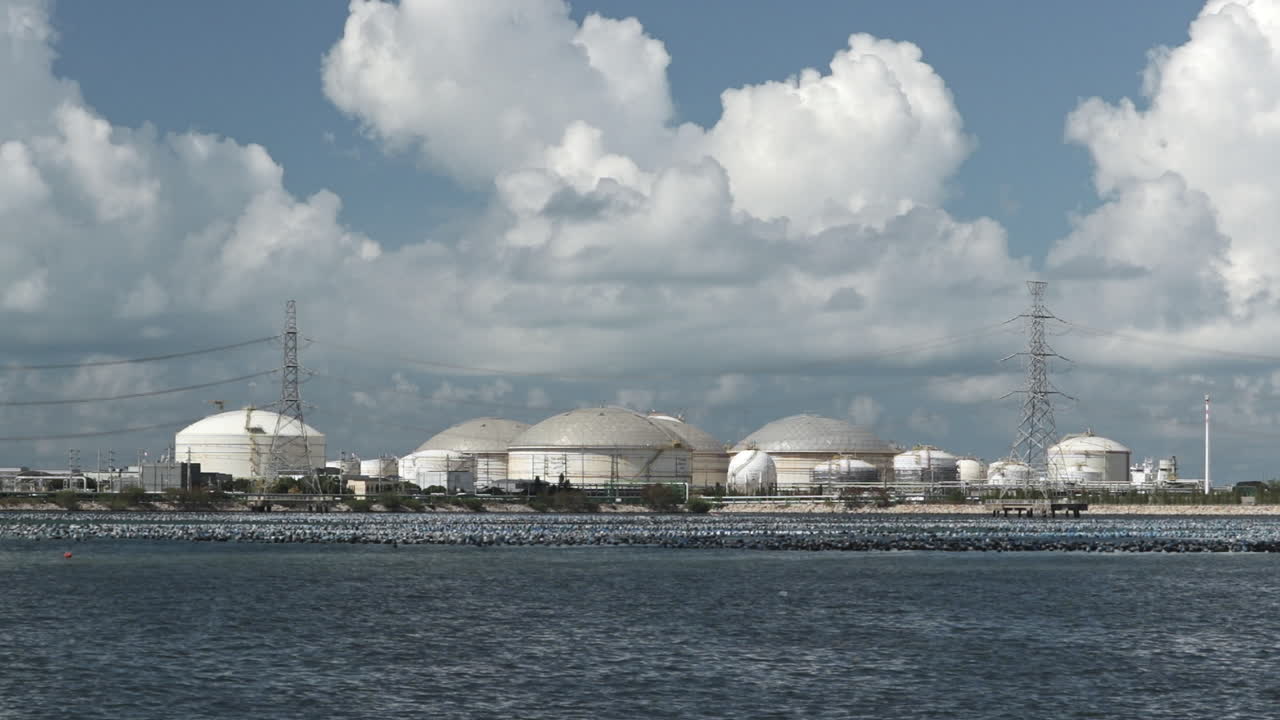 Serbatoi di stoccaggio del petrolio vicino al mare, presso Map Ta Phut. Infrastruttura di stoccaggio petrolchimico in un'area industriale costiera, adatta per concetti relativi a energia, petrolio e gas.