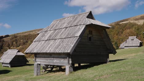 rustic wooden huts in kolašin, montenegro under a bright blue sky