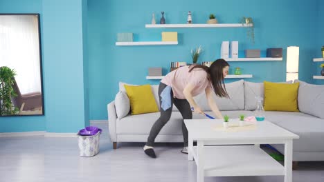 Happy-young-woman-washing-floors-with-cute-mop-and-dancing-at-home-enjoying-chores.