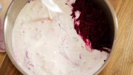 Pouring-kefir-into-bowl-with-ingredients-for-cold-beetroot-soup,-static-view