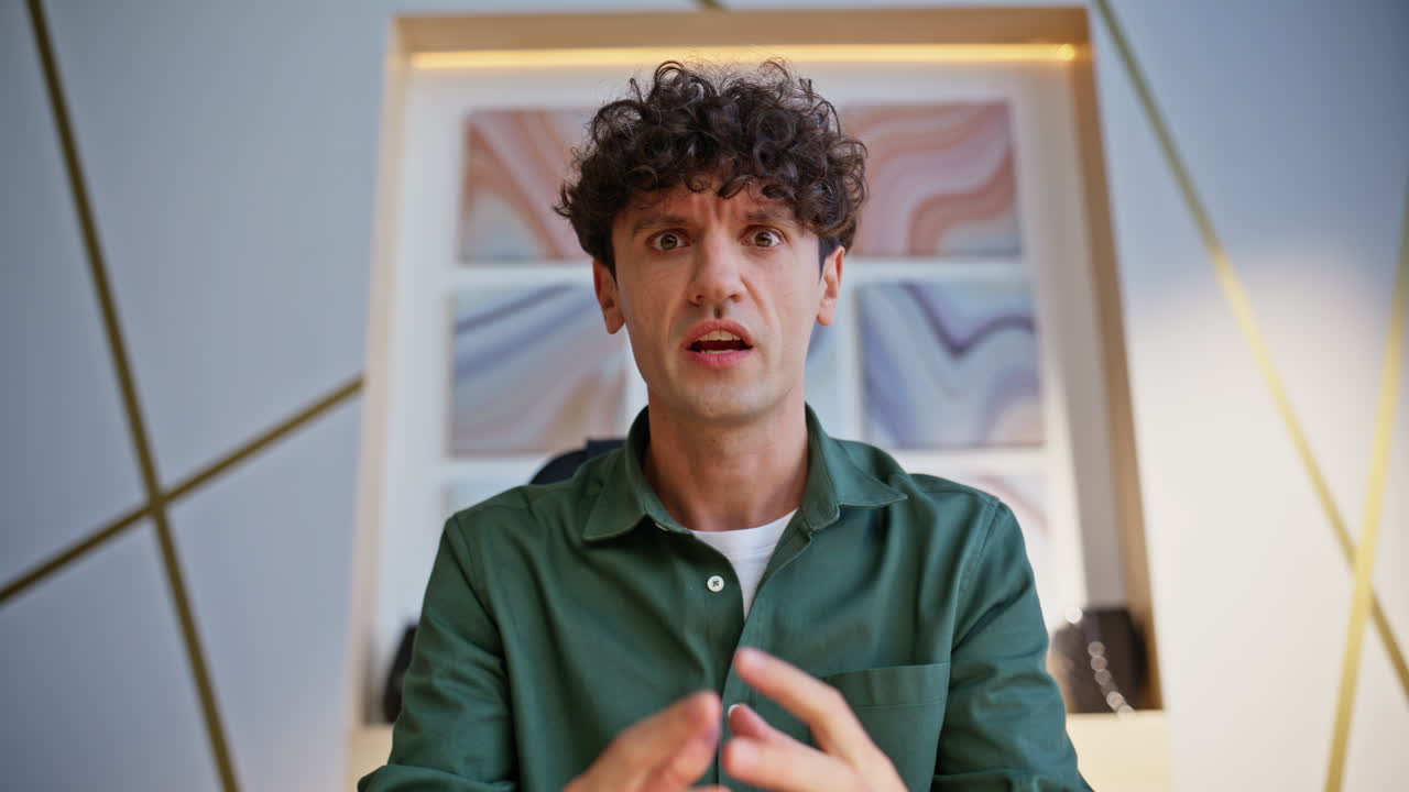 Portrait of a man with curly hair in a green shirt