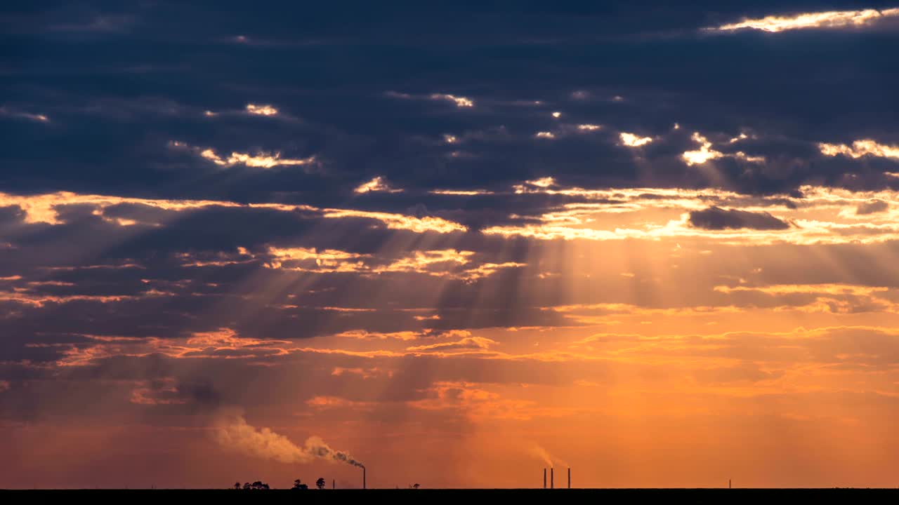 Time Lapse of Industrial pollution and smog sunrise with sun rays and dark clouds.