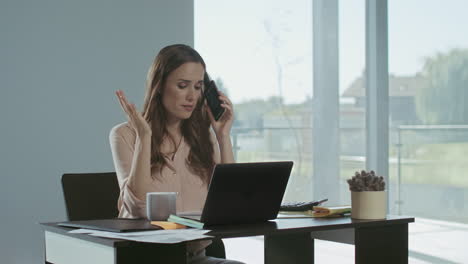 Business-woman-talking-mobile-phone.-Freelance-lady-working-on-laptop-computer.