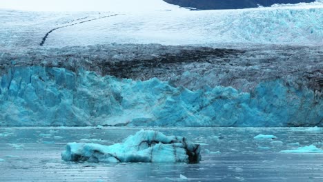 small icebergs in front of a massive antarctic glacier