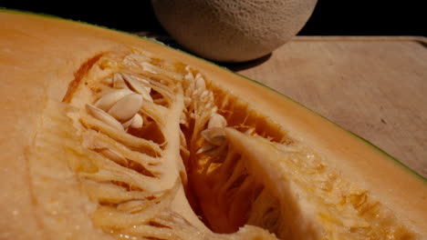 Close-up-slide-along-a-halved-cantaloupe-on-a-cutting-board