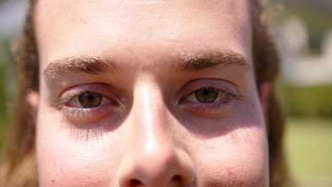 close-up of a young caucasian man smiling outdoors in a sunny day