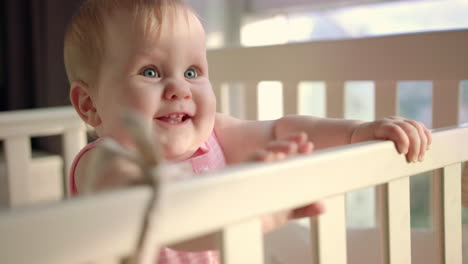 Smiling-toddler-standing-in-bed-at-home