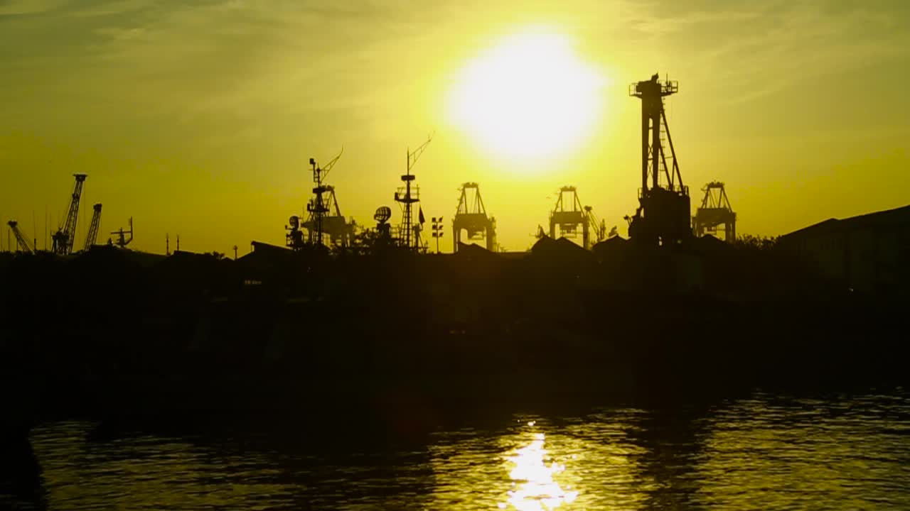 Sunset over a port with cranes