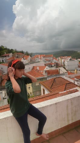 girl with headphones on a rooftop