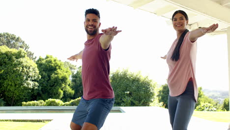 smiling couple practicing yoga outdoors, enjoying sunny day and fresh air