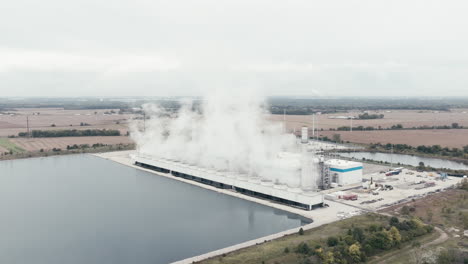 Central-Eléctrica-De-Gas-Natural-Junto-A-Un-Estanque-De-Refrigeración-En-El-Campo-Rural,-Aéreo