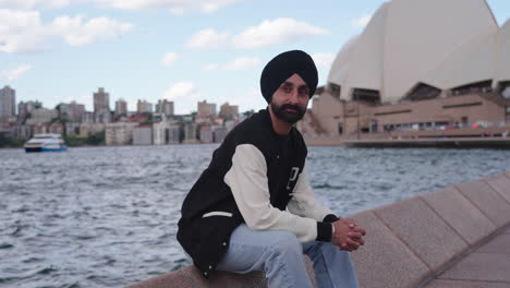 Hombre-Indio-En-Turbante-Sentado-Frente-A-La-Famosa-ópera-De-Sydney-En-Sydney,-Australia