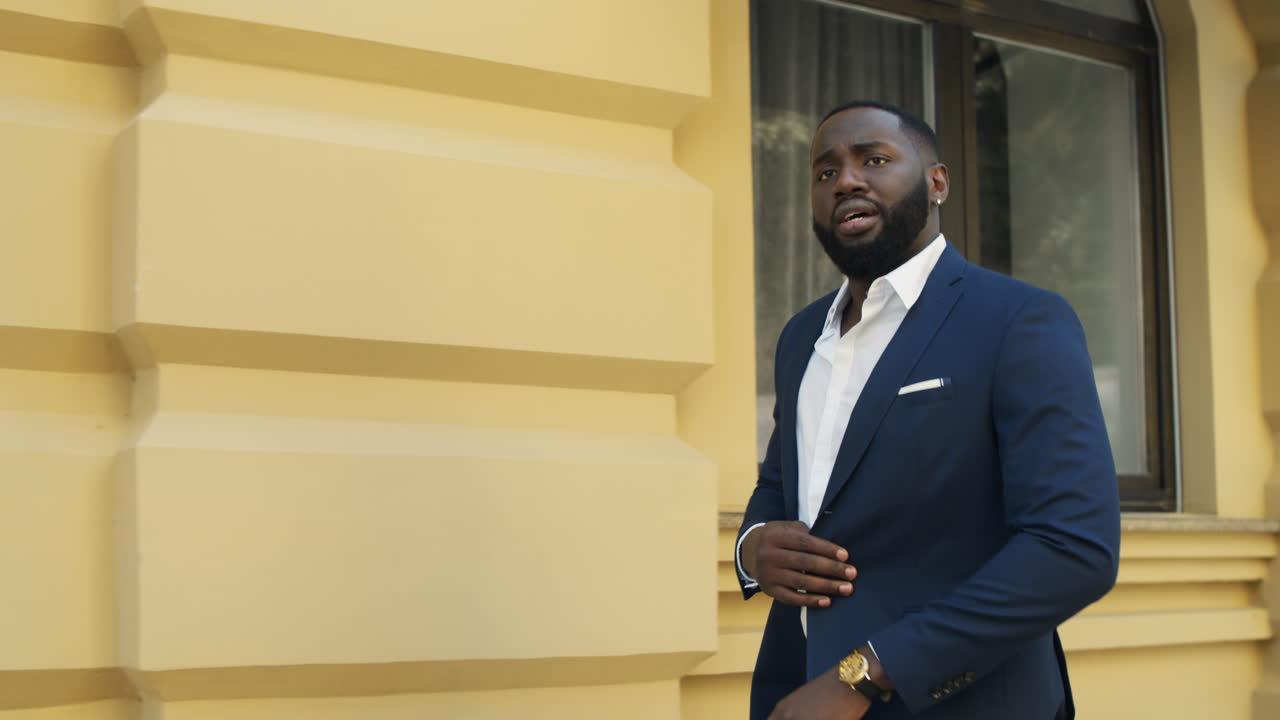 un hombre de negocios afroamericano caminando a toda prisa, un tipo afro yendo rápido por la calle urbana.