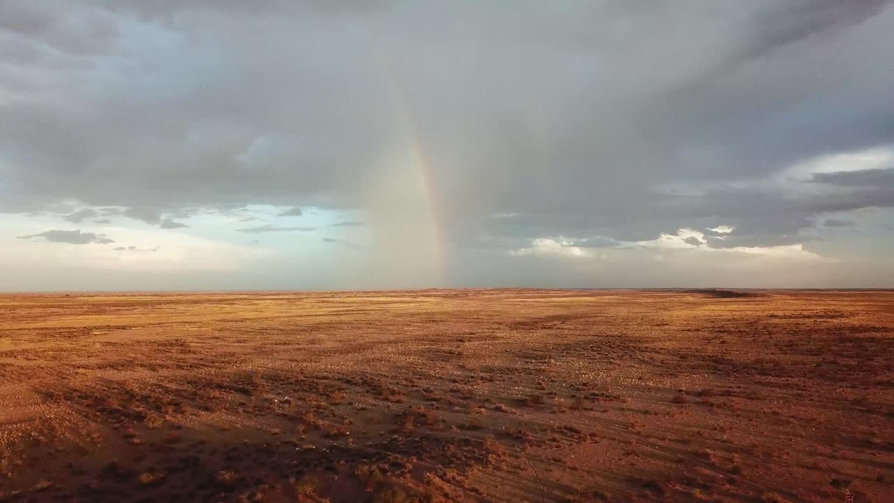 disparo de un dron de un arco iris en la distancia en una granja de ovejas namibia muy seca