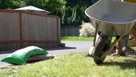 landscaper pushing a wheelbarrow in a lawn