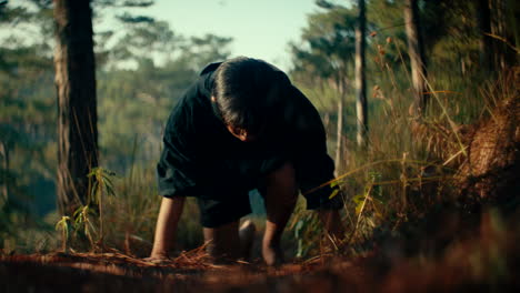 man crawling through forest path