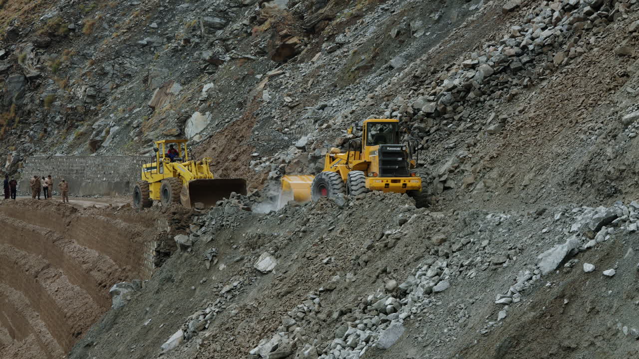 Two Yellow Bulldozers Clearing Up The Landslide Incident On Karakoram Highway In Dasu, Pakistan - close up